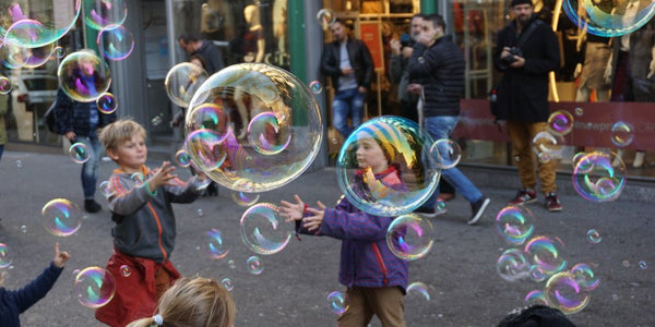 toddler playing with bubble gun toy in park